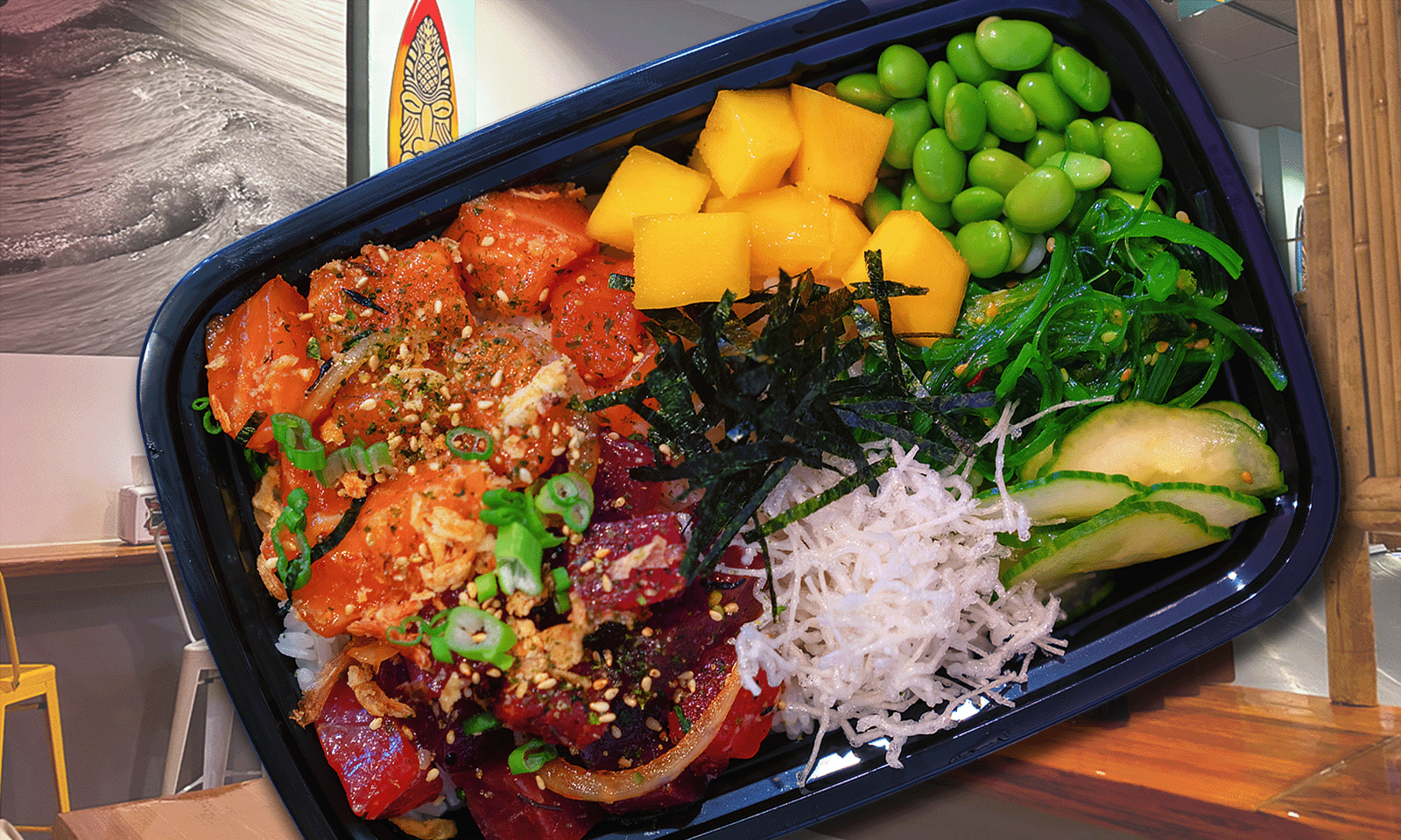 poke bowl in a black container with restaurant background